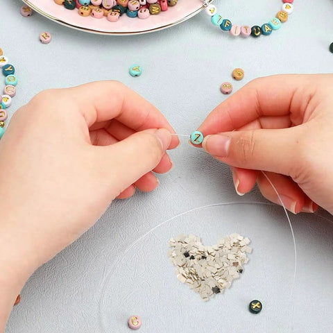 Hands threading a colorful bead with clear string, surrounded by 2 Packs Silver Soldering Sheets For Jewelry Make Secure Joints 0.08X0.08 Inch Precise Precut Soft Chips For All Metals And Creative Solder Work.