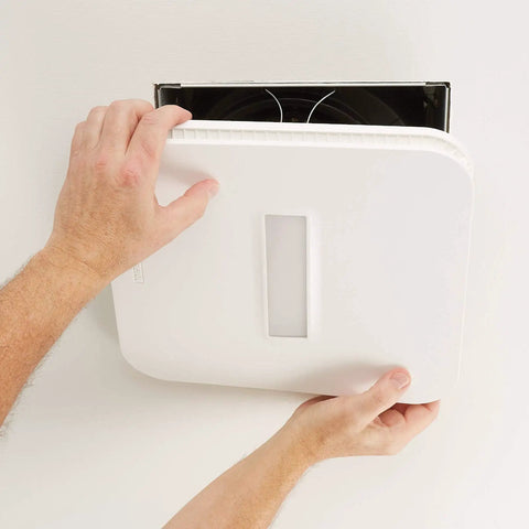 SurfaceShield Vital Vio Bathroom Exhaust Fan Grille With Disinfecting Violet Led Light being installed on a wall.