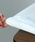 Person adjusting corner elastic of 6 Foot 30 Inch By 72 Inch Rectangle White Plastic Table Covers Party Ready Pack Of 5, Elastic Fitted Banquet