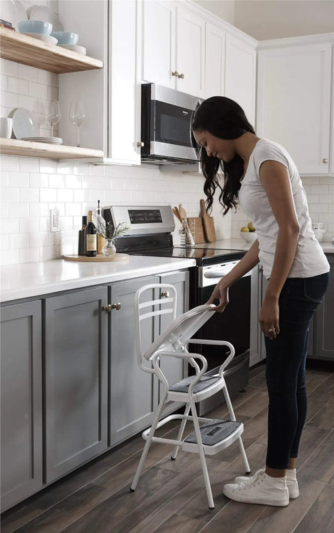 Woman using Retro Style Chair And Flip Up Step Stool In White With Vinyl Seat And Steel Frame in kitchen
