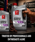 Synergy Gear MT 75W-80 GL-4 Full Synthetic Manual Transmission Fluid one gallon bottle on workshop table with gears in background