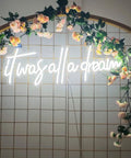 It Was All a Dream Neon Sign Lit Flexible LED Neon Light surrounded by floral decor on a tiled wall background