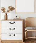 Dresser with Antique Bronze Drop Swing Cabinet Pulls 4 Pack, zinc alloy rustproof handles on white drawers in a modern living room.