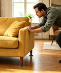 Man moving a sofa with 20 Pack Carpet Furniture Sliders 3.5 Inch Round Moving Pads Reusable Glide For Tables Chairs Cabinets And More
