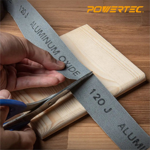 Pro Grade Emery Cloth Sandpaper Roll 120 Grit 1.5 In X 10 Yards Aluminum Oxide Abrasive being cut for metal and woodworking.