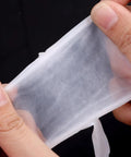 Hands stretching a piece of Six Pack PTFE Plumbing Tape Sealant For Quick Leak Stops At Pipe Fittings And Sink Drains Waterproof Thread Sealant Tape For Do It Yourself Repairs Pro Grade Leak Prevention For Home And Industrial Use