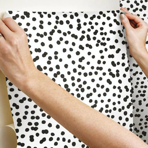 Hands applying Black and White Confetti Peel and Stick Wallpaper Removable Self-Adhesive Roll for Easy No Mess Decor, 20.5 in x 16.5 ft