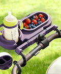 3 In 1 Modular Stroller Snack Tray With Universal Fit Dual Lock Attachment holding bottle and berries on a stroller handle