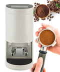 Straight Up Automatic Espresso Tamper 58mm Coffee Press With Digital Touchscreen showing tamper and ground coffee in hand.