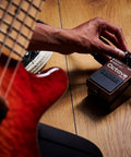 Musician adjusting Octave Pedal OC-5 For Guitar And Bass With Mono And Poly Modes, dry direct output, and lowest-range poly setting.