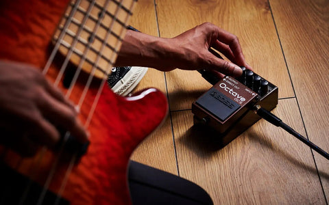 Musician adjusting Octave Pedal OC-5 For Guitar And Bass With Mono And Poly Modes, dry direct output, and lowest-range poly setting.