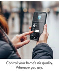 Person using smartphone to control Whisper Quiet Compact Air Purifier For Whole Room Coverage Pet And Allergy Friendly Fully Sealed