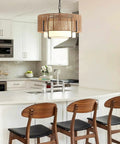 A Straight Up Game Changer 4Light Rattan Chandelier With Linen Drum Shades over a modern kitchen island with chairs.