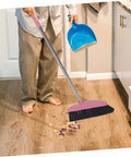 Legit Heavy Duty Pink Broom With Sturdy Steel Handle And Ultra Soft Bristles For Zero Sweat Indoor And Outdoor Floor Cleanup Compact Reusable Dust Brush That Really Cleans in use sweeping up debris on wood floor.