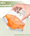 Hand holding a leakproof 32 Oz Borosilicate Glass Food Storage Container With Lid Pack Of 4 with fruit inside, demonstrating seal quality.