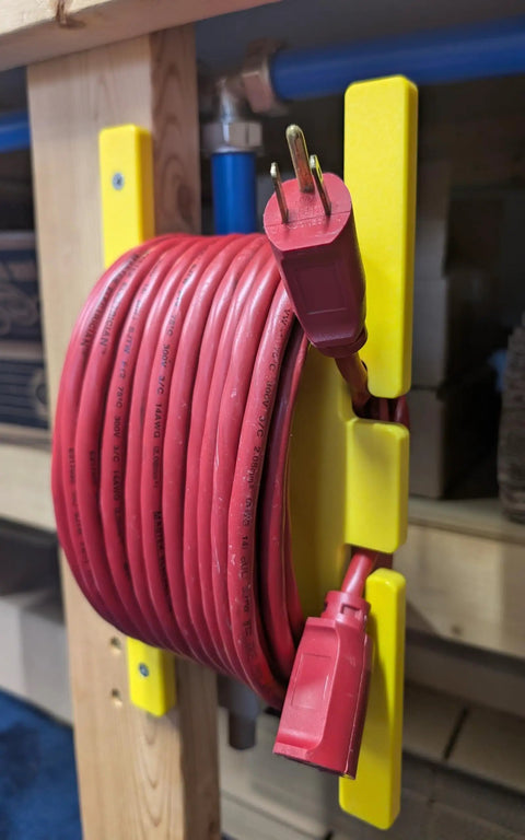 Heavy Duty Extension Cord Reel And Yellow Cord Organizer Set Two Pack That Holds 100 Feet Each mounted on wood wall
