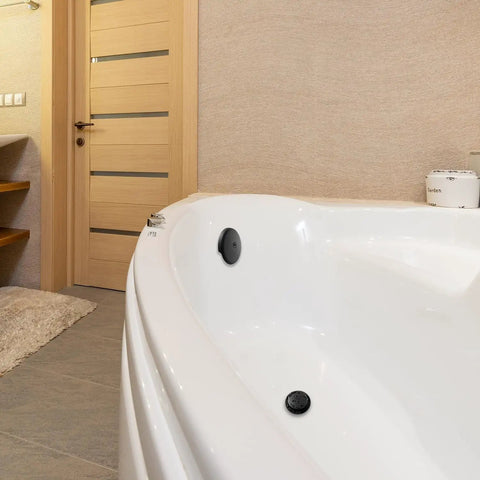 Matte Black Single Hole Bathtub Drain Overflow Plate With Solid Zinc Body And Matching Mounting Screws For A Sleek Look And Zero Drama Fast Install visible in a white bathtub.
