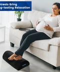 Pregnant woman using under desk foot rest with soft foam and washable removable cover for home office and car use on a couch.