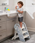 Hella Steady Adjustable Toddler Step Stool With Handles Converts From 3 To 2 Setup As Kiddos Grow Non Slip Safety Footrest For Bathroom Sink And Kitchen Counter Grey, toddler brushing teeth on step stool.