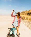 Person drinking from Portable Squeeze Water Filtration System With Two 32 Oz Pouches, Straw, And Hydration Pack Adapter on beach