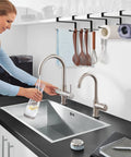 Absolute Knockout Tumbler Lid Organizer That Snaps Right Onto Standard Cups And Keeps Your Counter Dead Clean Without Any Hassle While Holding Ten Sip Lids In Chill Modern Black Design positioned above kitchen sink.