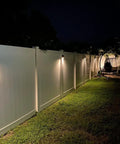 Lit Solar Fence Lights LED Outdoor Wall Lights IP65 Waterproof Eight Pack With Dual Color Modes illuminating a garden fence.