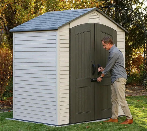Man securing Built Tough Outdoor Storage Shed 7 x 4.5 Ft with steel reinforced construction and double wall HDPE in backyard