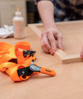 Heavy-Duty Adjustable Band Clamp For Woodworking And Framing, 15-Foot Strap, Self-Locking Ratcheting Handle on woodwork table.