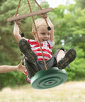 Child playing on Disc Swing For Kids With 7 Ft Adjustable Height, Monkey Bars, Hanging Tree Seat, Backyard Outdoor Play Set In Green.