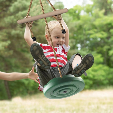 Child playing on Disc Swing For Kids With 7 Ft Adjustable Height, Monkey Bars, Hanging Tree Seat, Backyard Outdoor Play Set In Green.