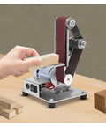 Mini Electric Belt Sander And Polisher Machine Desktop Grinding Tool in use, sanding wood block, compact design with stainless frame.