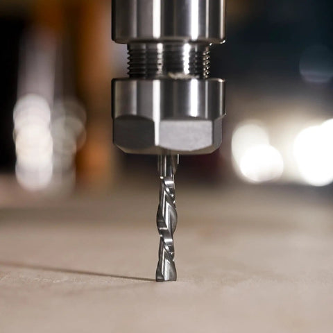 Close-up of Extra Long Four Inch Spiral Downcut Router Bit Pro Grade With Half Inch Shank in CNC router setup for wood carving.