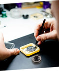 Person using tweezers to repair watch in Complete Mechanical Alarm Clock Repair Kit With Spring Steel Return Spring Assembly And Parts