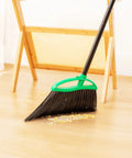 Heckin Tough Heavy Duty Brooms Two Pack With 55 Inch Long Handles Angled Head sweeping debris off wooden floor.