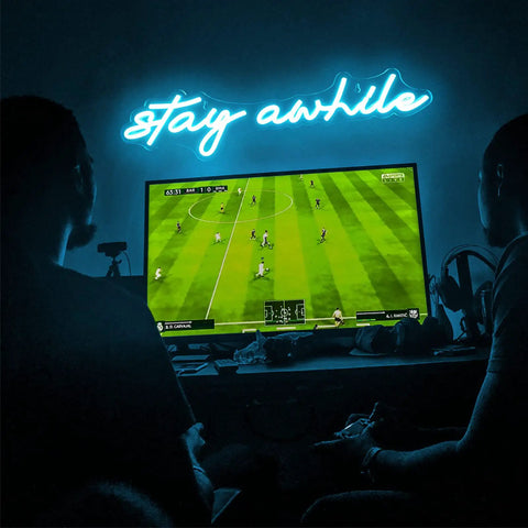 Blue "Stay Awhile" neon sign on wall above TV setup, USB powered LED bar light for bedroom, home office, party 19.7x5 inches