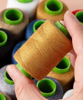 Close-up of a spool from Ten Color Sewing Thread Kit With Heavy Duty Denim Grade Polyester Spools 20s/3 Thick Thread Includes Needles Needle Threader And Thimble 200 Yards Per Roll Perfect All In One For Jeans And Garment Repairs