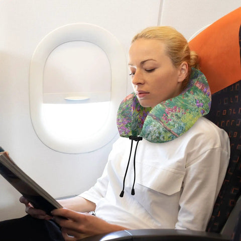 Woman using Monet Iris Garden Travel Neck Pillow With Memory Foam Core Removable Washable Cover on airplane, supports neck.