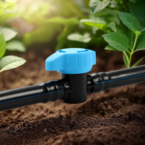Close-up of a 10 Pack Half Inch Drip Irrigation Shut Off Valve Inline 16mm Barbed Fittings on garden tubing among plants