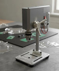 Stgfyxgs Mini Drill Press on a workbench, compact benchtop drilling machine with adjustable power for wood and metal projects.