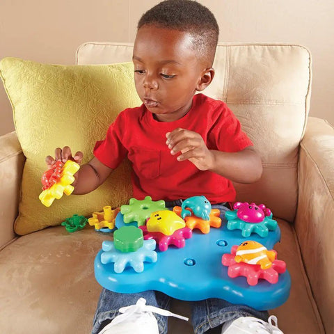 Child playing with Ocean Wonders Build And Spin Gears Toy Set, 17 Piece Preschool STEM Construction Kit For Toddlers And Kids 18 Months And Up.