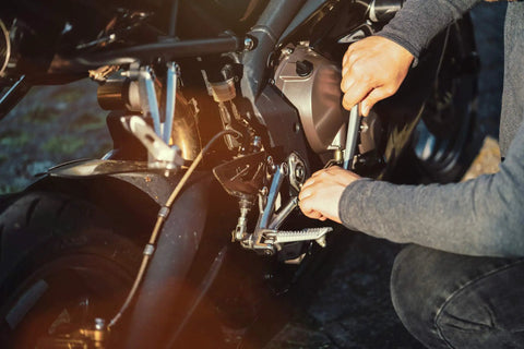 Person using Essenti-Economy Motorcycle Tool Kit for Harley-Davidson and V-Twin Hybrids on motorcycle roadside repair