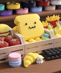 Colorful display of cute food-shaped toys, featuring a yellow toast character, bright vegetables, fries, and a croissant.