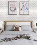 Bedroom featuring Peel And Stick 3D Foam Brick Wall Panels White 30 Pack Self Adhesive Faux Stone Wallpaper with artwork above bed.