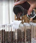 Pouring coffee beans into a Single Dose Coffee Bean Storage Jars 14 Piece Glass Canisters With One Way Valve.
