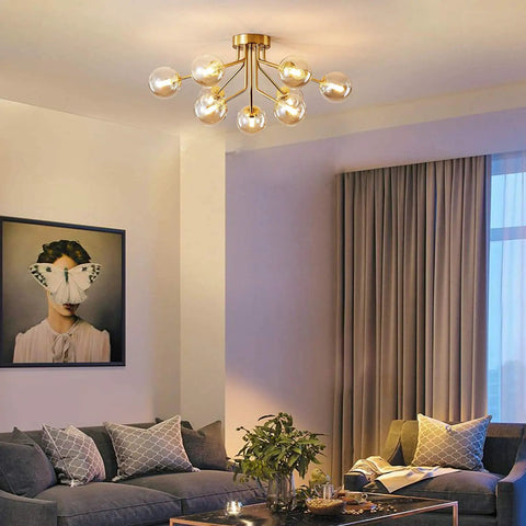 Sleek 9 Light Sputnik Chandeliers With Dope Brass Finish And Glass Globe Orbs in a modern living room setting