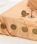 Top Shelf Bronze Decorative Upholstery Tacks With Flat Head 100 Piece Furniture Hardware Kit For DIY Restoration Projects shown on fabric.