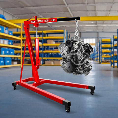 Heavy Duty 2 Ton Folding Hydraulic Engine Hoist Handling Up To 4000 Pounds Without Breaking A Sweat For Home Garages And Pro Auto Shops lifting an engine in a warehouse.