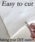 Ceramic fiber insulation blanket close-up being cut with pink-handled scissors; white, 39.4 x 24 x 0.5 in.