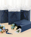 Four Pack 9 Inch Gift Bags In Premium Blue With Tissue Paper Medium Size 7x4x9 Inches arranged with floral decor.