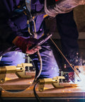 Welder using 600 Amp Welding Ground Clamp, Beefy Solid Brass Grounding Clamp For Heavy Duty Arc Welding, close-up on clamp.